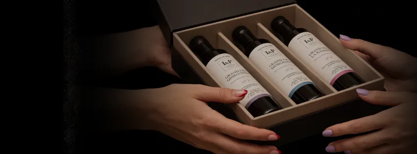 Mani che aprono un cofanetto regalo I&P con tre bottiglie di olio extravergine